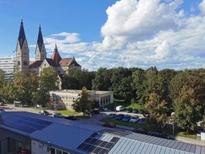 eine Gruppe von Sonnenkollektoren auf einem Gebäude mit einer Kirche in der Unterkunft Apartment in Wels