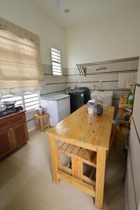 una gran cocina con una mesa de madera. en D'Ja Smoke Homestay, en Kampong Wakaf Tengah