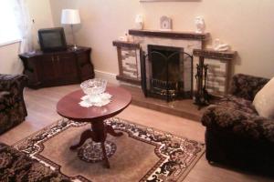 a living room with a table and a fireplace at Bridge House in Glenties
