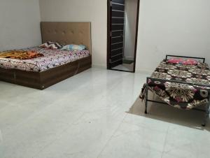 a bedroom with a bed and a table in it at The White Sand Guest House in Naya Raipur