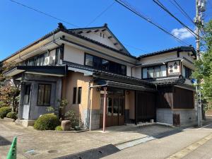 ein japanisches Haus an der Seite einer Straße in der Unterkunft Daibutsu Ryokan in Takaoka