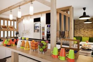- une cuisine avec un comptoir avec des tasses colorées dans l'établissement ibis Styles Paris Buttes Chaumont, à Paris