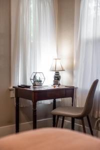 a desk with a lamp and a chair next to a window at 738 E Yale in Fresno