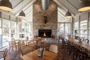 a restaurant with tables and chairs and a fireplace at Camden Valley Inn in Camden