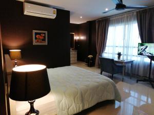 Klong Muang Beach Apartment في كلونغ موانغ بيتش: غرفة نوم بسرير ومكتب ونافذة