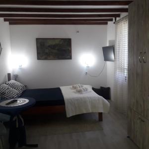 a bedroom with a bed and a table and lights at Sljivik in Niš