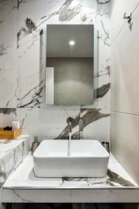 a bathroom with a white sink and a mirror at Xenia's apartment in Ayiá