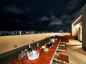 a long table with wine glasses on a rooftop at Rakuten STAY Naha-Miebashi Suite Room in Naha