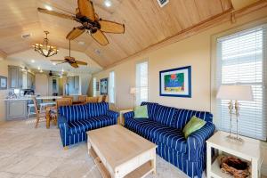 een woonkamer met blauwe banken en een plafondventilator bij Day Dreamer in St. George Island