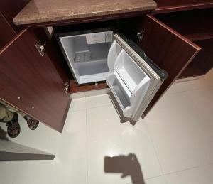 an open refrigerator with its door open in a kitchen at Daffodil Inn in Velankanni