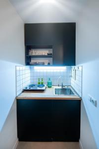 a kitchen with black cabinets and a sink at HB apartments Tabukashvili in Tbilisi City