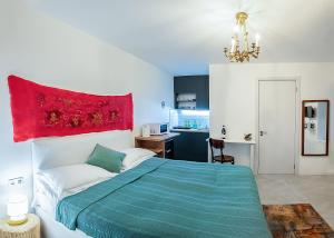 - une chambre avec un lit bleu et une couverture rouge dans l'établissement HB apartments Tabukashvili, à Tbilissi