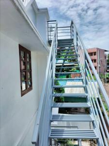 una escalera que conduce a un edificio blanco en joseys homestay, en Kochi