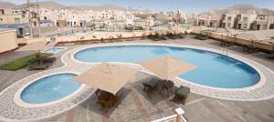 a large swimming pool with umbrellas on top of a building at Casa Club Vacacional in Ica