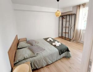 1 dormitorio con 1 cama con 2 toallas en Odos Tarbes Très beau T3 avec petite terrasse et pkg, en Odos