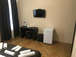 a room with a small refrigerator and a television at Family Guest House in Tbilisi City