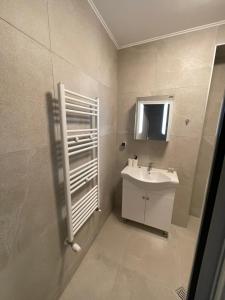 W białej łazience znajduje się umywalka i lustro. w obiekcie Movie flats w mieście Sofia