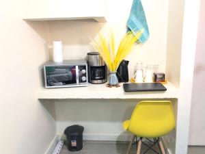 a kitchen counter with a yellow chair and a microwave at Walk to Strathmore Uni, Java, Wilson Airport,tmall in Nairobi