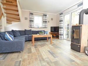 a living room with a blue couch and a tv at Haus Breitenstein in Baabe