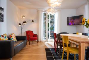 a dining room and living room with a table and chairs at Boutique Villa J87 in Interlaken