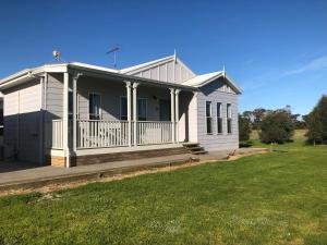 a white house with a porch and a yard at CandE on Samphire in Kingscote