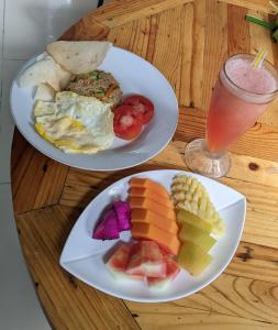 dos platos de comida en una mesa de madera con una bebida en Ubud Dream, en Ubud