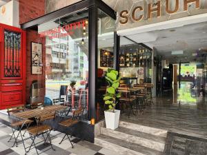a restaurant with tables and chairs in front of a store at Arenaa Star Hotel in Kuala Lumpur