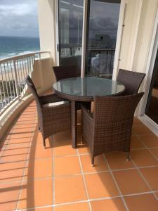 una mesa y sillas en un balcón con vistas al océano en Stunning 2 bedroom Ocean View Apartment en Gold Coast