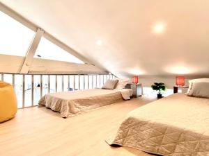 a bedroom with two beds and a large window at Élégante maison au bord du bassin Arcachon in Gujan-Mestras