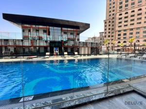 una gran piscina frente a un edificio en Homely 1BR at Binghatti Avenue Al Jaddaf by Deluxe Holiday Homes, en Dubái