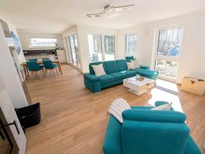 a living room with a blue couch and a table at Haus Arkona Penthouse - Strandräuber in Ostseebad Sellin