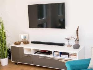 a living room with a tv on a white wall at Haus Arkona Penthouse - Strandräuber in Ostseebad Sellin