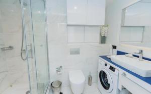 Un baño con inodoro, lavabo y ducha. en Panoramic Sea and City View Aparthotel In Orbi City Batumi, en Batumi 51 fotos más