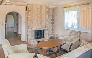 a living room with a fireplace and a table and chairs at 4 Bedroom Lovely Home In Rowy in Rowy