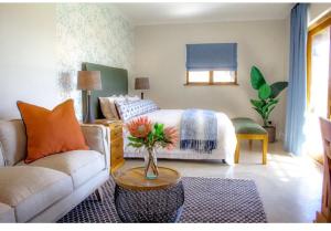 a living room with a bed and a couch at Simbavati Fynbos on Sea Cottage in Sedgefield