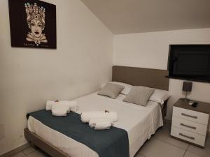 a bedroom with two beds and a flat screen tv at mungiBEDdu Apartment in Catania