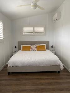 um quarto branco com uma cama e uma ventoinha de tecto em Palm Beach the best trending place on the Coast em Gold Coast