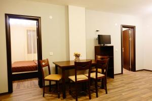 een kamer met een tafel en stoelen en een televisie bij ENIS Hotel с минерален басейн in Sapareva Banya