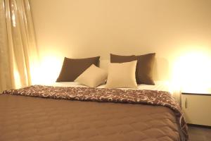 een bed met verschillende kussens in een kamer bij ENIS Hotel с минерален басейн in Sapareva Banya