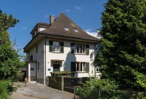une maison blanche avec un toit marron dans l'établissement Boutique Villa J87, à Interlaken