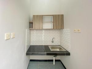 eine Küche mit Spüle und Arbeitsplatte in der Unterkunft RedDoorz Plus at Orange Diponogoro Palangkaraya in Palangkaraya
