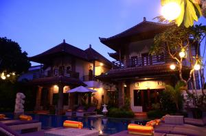 a building with a pool in front of a house at Puri Sading Hotel in Sanur
