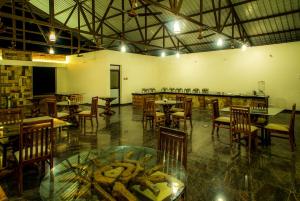 a restaurant with tables and chairs and a counter with food at Dandeli Nature Resort in Dandeli