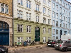 un edificio verde con bicicletas estacionadas frente a él en Sanders Lake - Pleasant Two-Bedroom Apartment in Downtown Copenhagen, en Copenhague