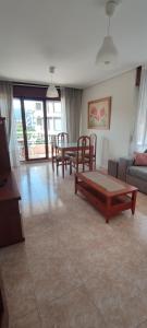 sala de estar con sofá, mesa y sillas en Apartamento Turístico Los Altos en Noja