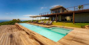 een huis met een zwembad en enkele stoelen bij Simbavati Fynbos on Sea Cottage in Sedgefield