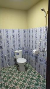a bathroom with a toilet and a shower at Andira Homestay Labuan Bajo in Labuan Bajo