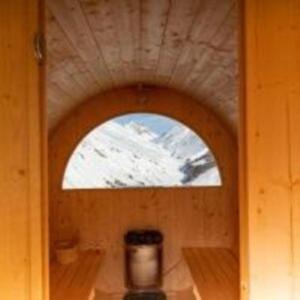 - une fenêtre à l'arrière d'une chambre en bois avec accès dans l'établissement BAITA NOEMI, à Livigno