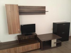 a room with a flat screen tv and a desk with a television at Elite Apartments is located in the old town of Pomorie in Pomorie