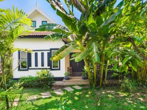 a white house with trees in front of it at Banana Resort, le petit nid de Caro in Phumĭ Réach Born (2)